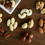 Close-up of various nuts on a wooden table, showcasing healthy snacking options.